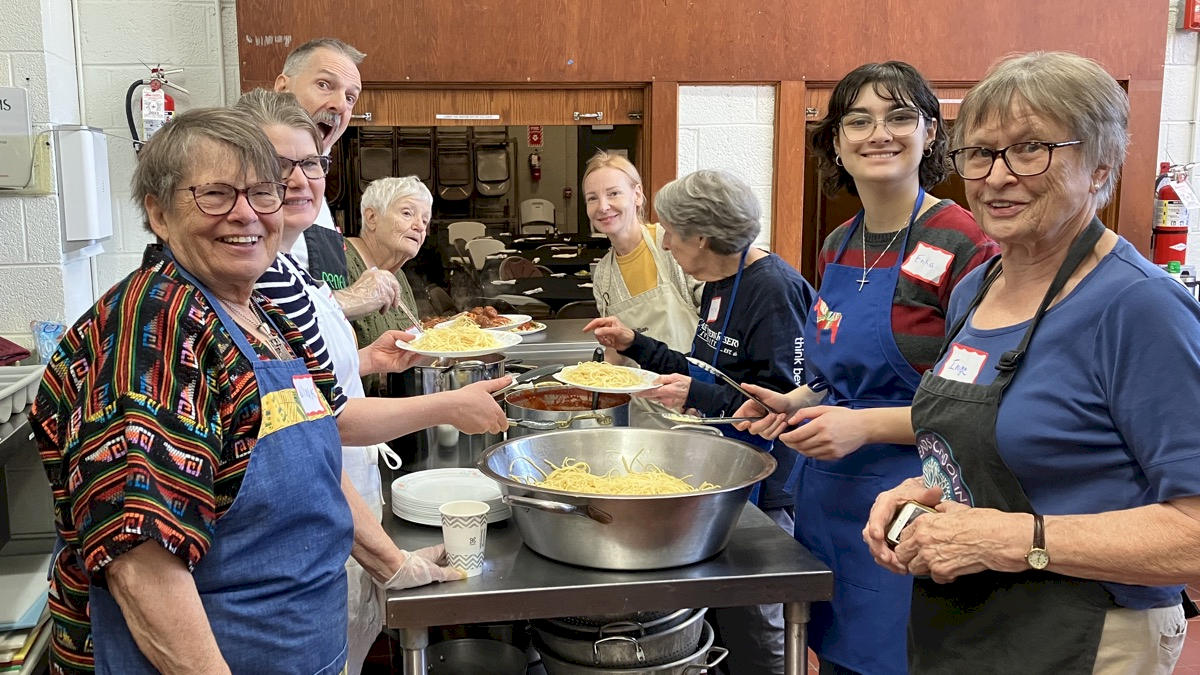 Multi-age group serves up pasta at a soup kitchen event. /images/library/large/soup_kitchen_group_prep.jpeg